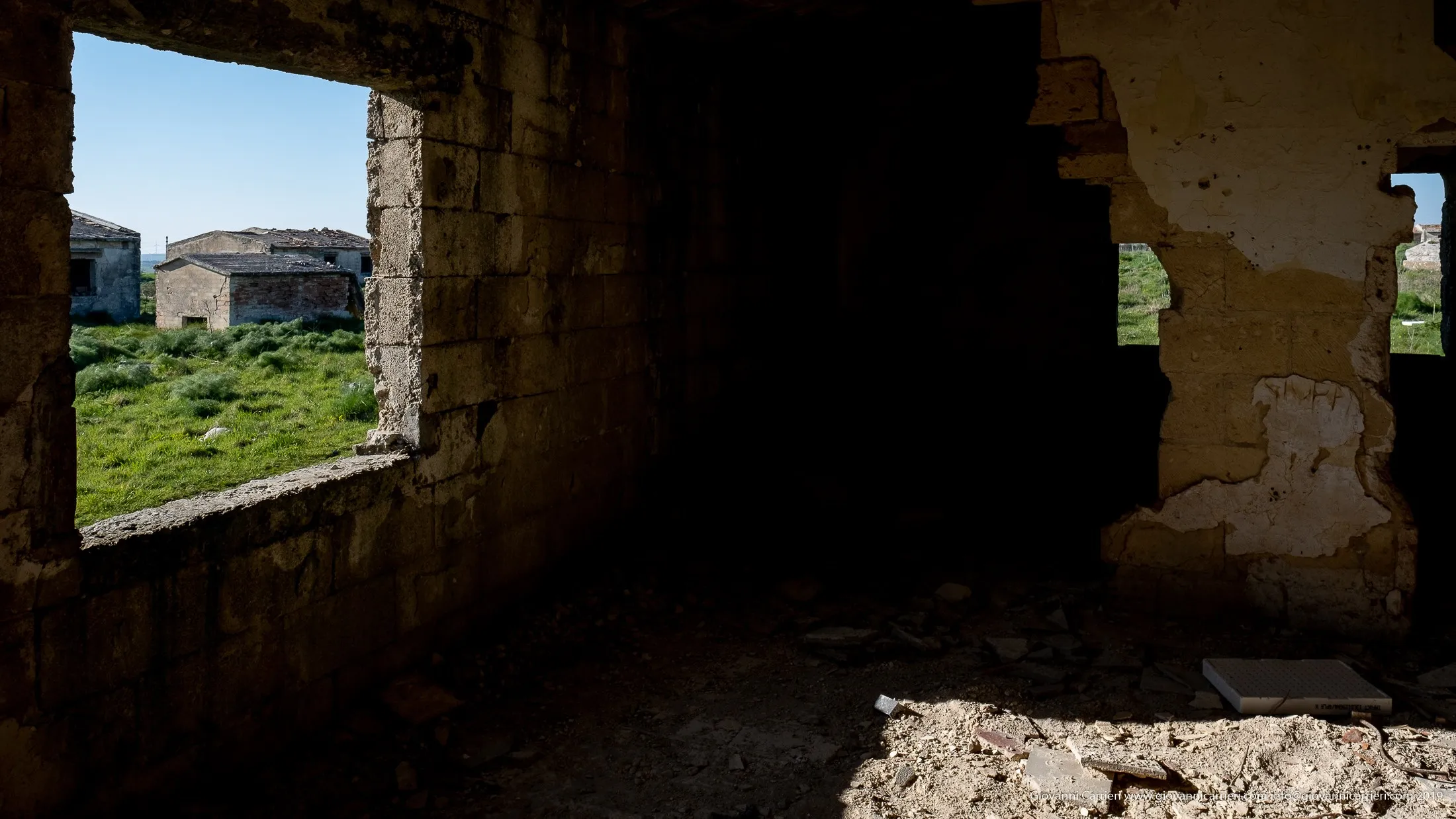 Interno di casa colonica con vista sui ruderi