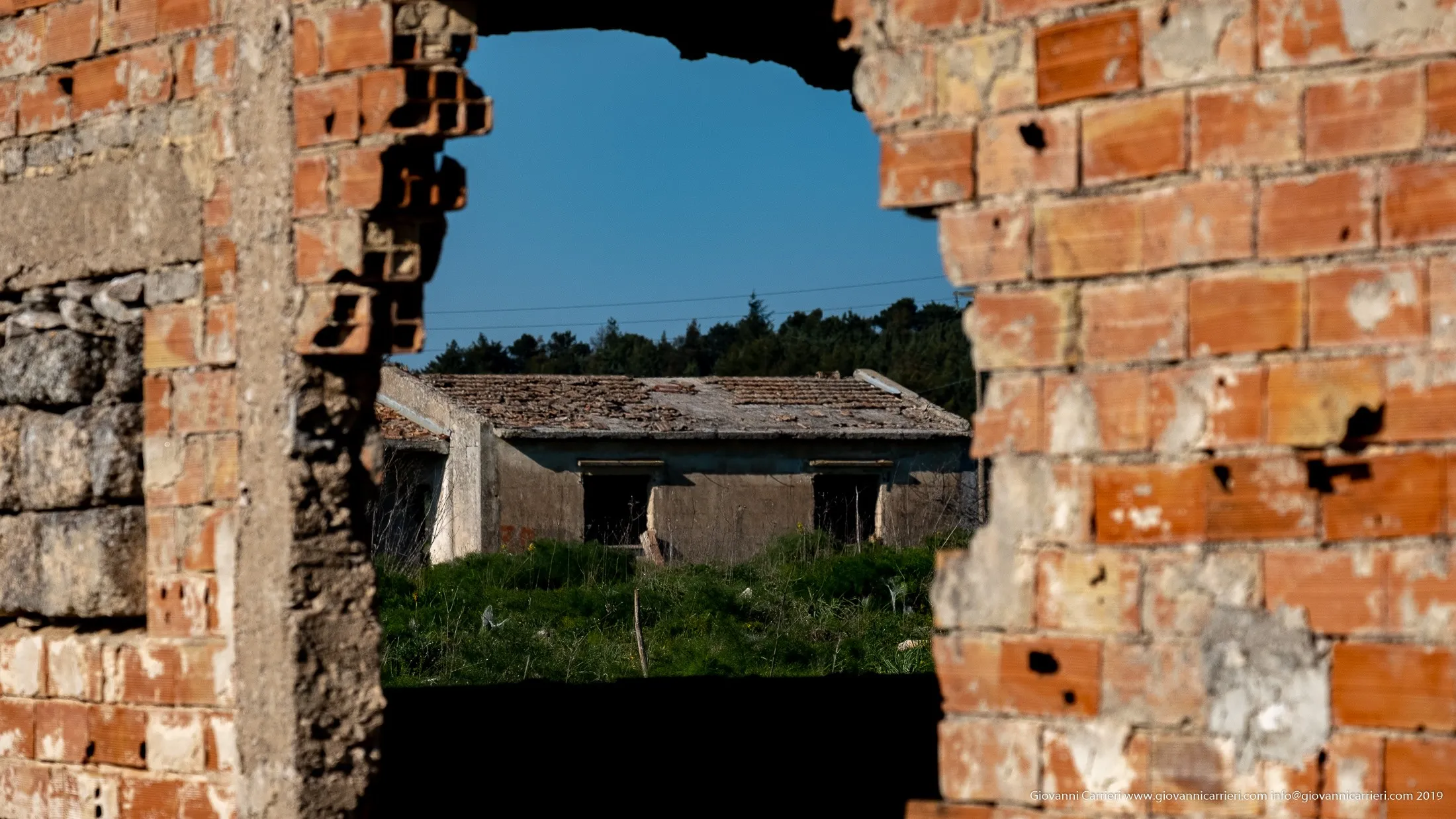 Varco tra mattoni forati con vista su rudere