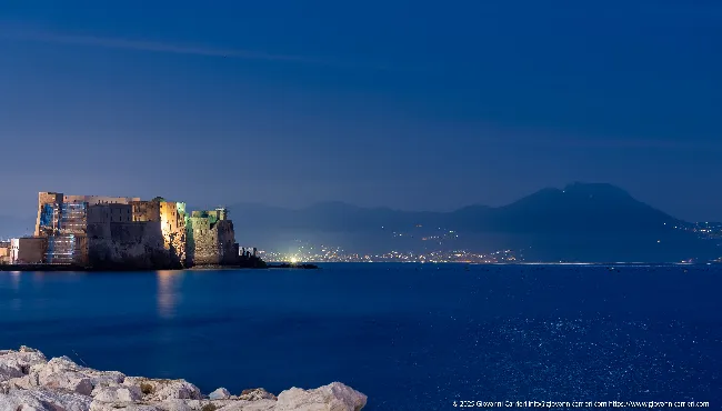 Castel dell'Ovo e Vesuvio, veduta notturna dal Golfo di Napoli