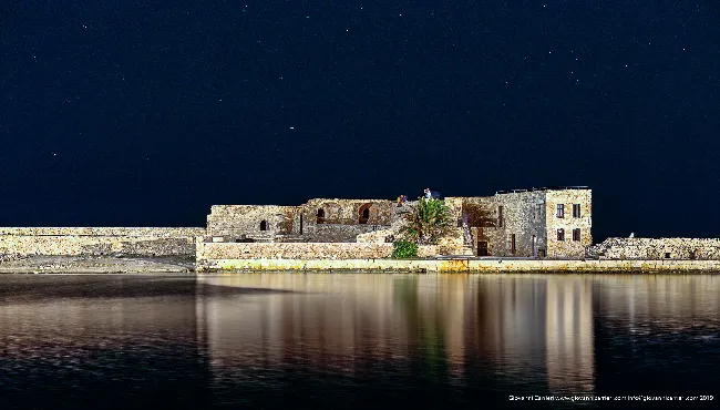 Chania Venetian fortress reflected in the harbor at night