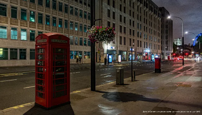 Red telephone box at night in London