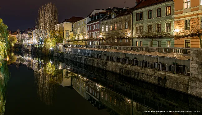 Fiume Ljubljanica di notte con riflessi delle case barocche